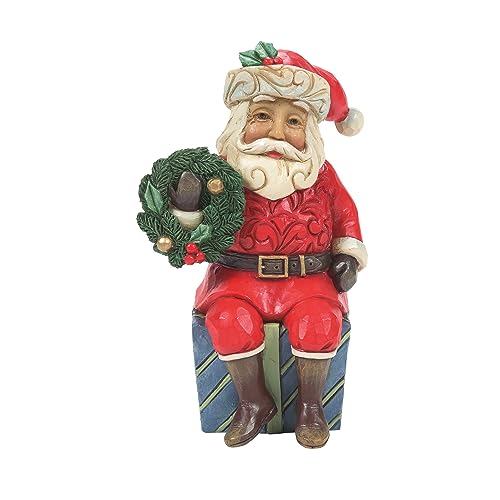 Enesco Jim Shore Heartwood Creek Dekofigur Weihnachtsmann sitzt auf Geschenken, 9,5 cm, mehrfarbig von Enesco